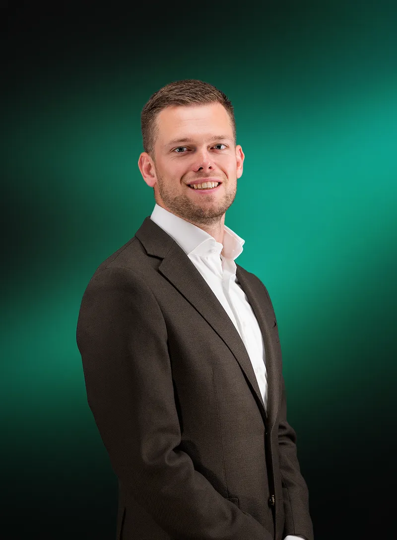 Portret van Gerwin van der Kolk tegen een groene achtergrond