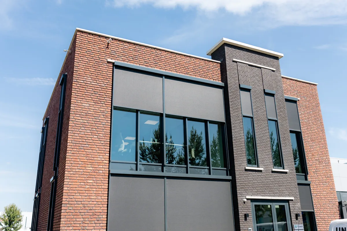 Kantoorpand Modern kantoorpand met een rode bakstenen gevel en grote ramen